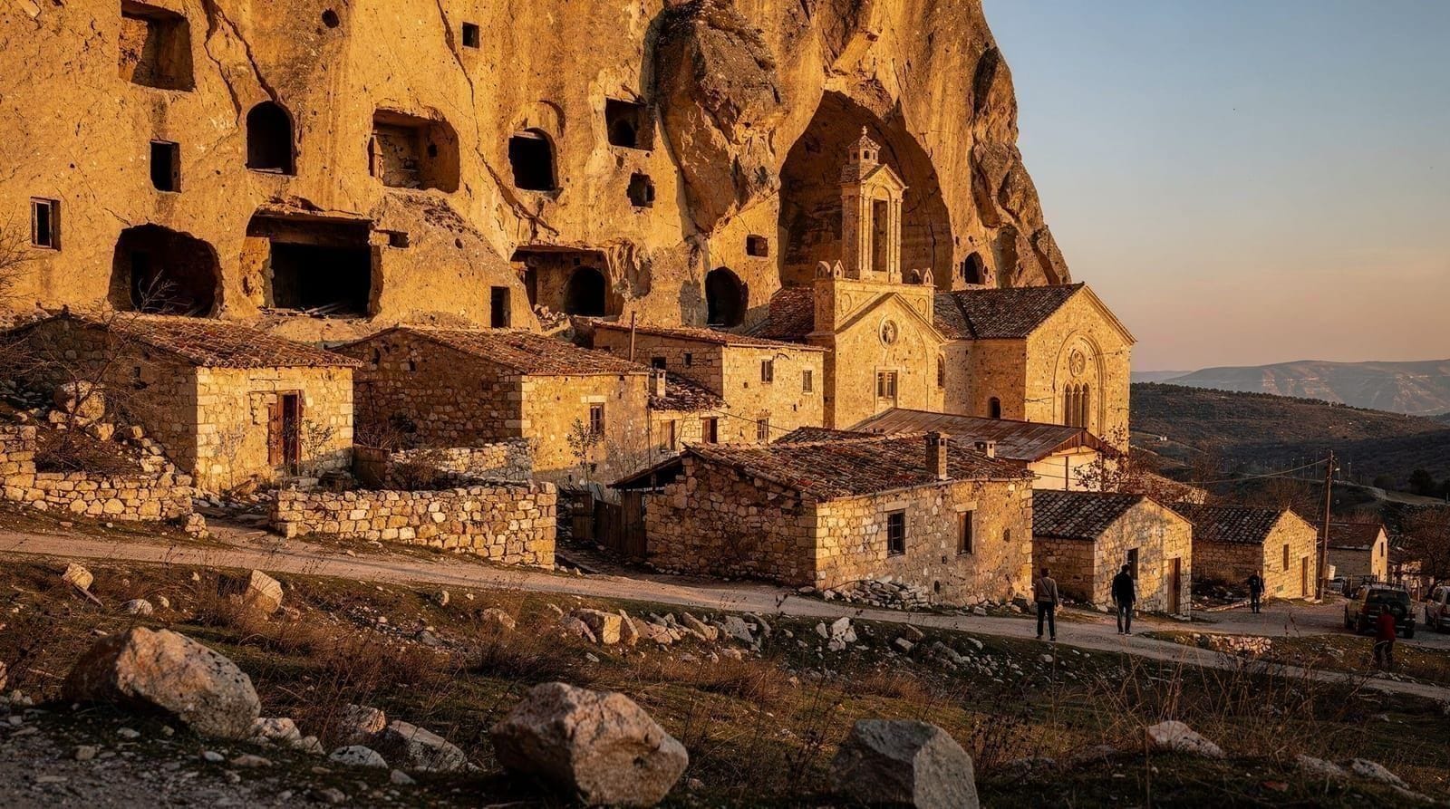 Çavuşin: cave houses beneath a cliff-cut church